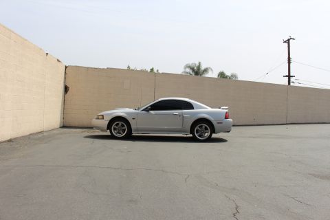 2002 Ford Mustang - Side view of a silver 2002 Ford Mustang coupe parked outdoors.