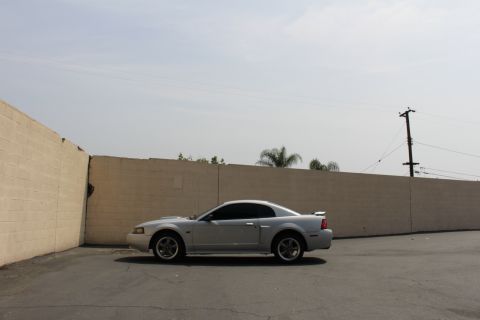 2002 Ford Mustang - Side view of a silver 2002 Ford Mustang coupe parked outdoors.