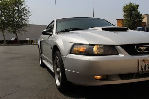 2002 Ford Mustang - Silver 2002 Ford Mustang parked outdoors, captured from a low angle showing the front right side.