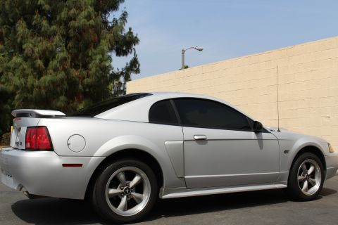 2002 Ford Mustang - Side profile of a silver 2002 Ford Mustang coupe with tinted windows.