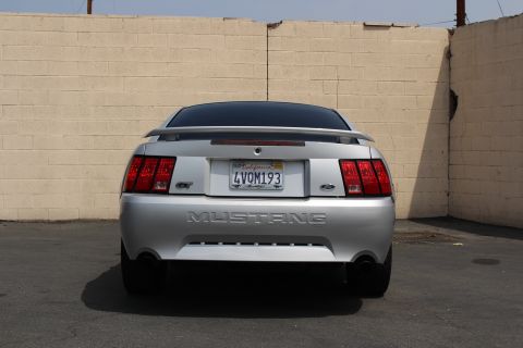 2002 Ford Mustang - Rear view of a silver 2002 Ford Mustang GT, showing the 'Mustang' badging and California license plate.