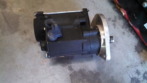 1988 Ford Bronco - Close-up of an unidentified black automotive part with a silver mounting flange.