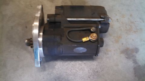1988 Ford Bronco - A starter motor, a crucial component for igniting a vehicle's engine, is shown here on a concrete surface.