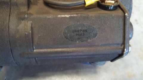 1988 Ford Bronco - A close-up view of a black automotive component with a label containing numbers and letters.