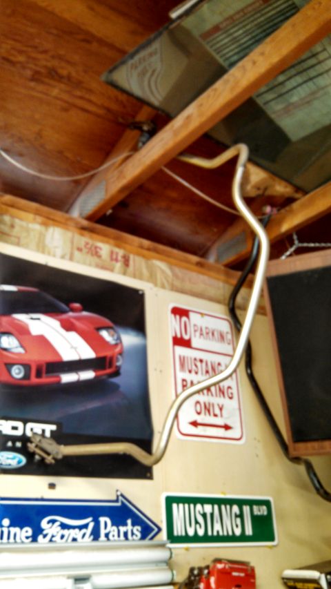 1988 Ford Bronco - A metal pipe is suspended from the ceiling in a garage, with various automotive signs visible on the wall.