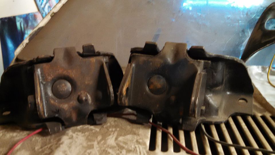 Two used engine mounts with red wires attached