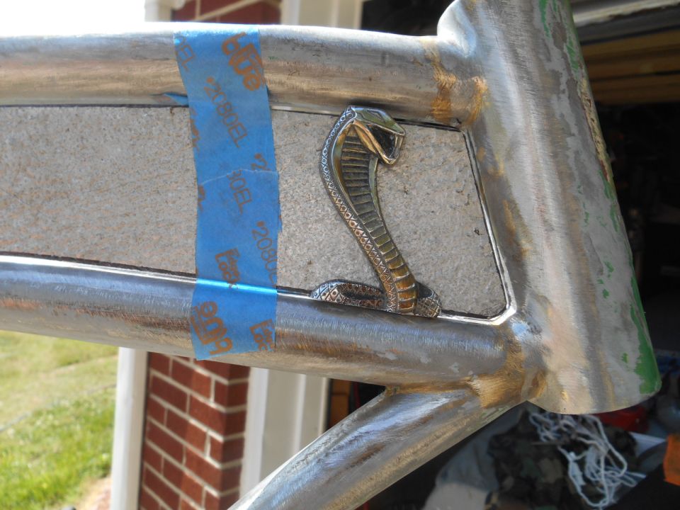 Cobra emblem on a metal frame, taped with blue painter's tape