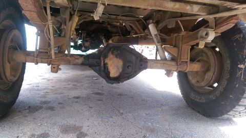 1976 Ford F-250 - Underside view of a truck's rear axle and suspension, showing signs of rust and wear.