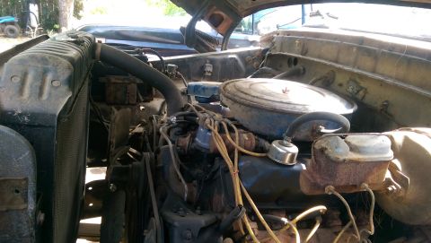 1976 Ford F-250 - The engine compartment of an older vehicle shows various components under the hood.