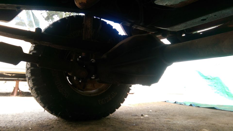 Undercarriage view of a truck's rear differential and tire