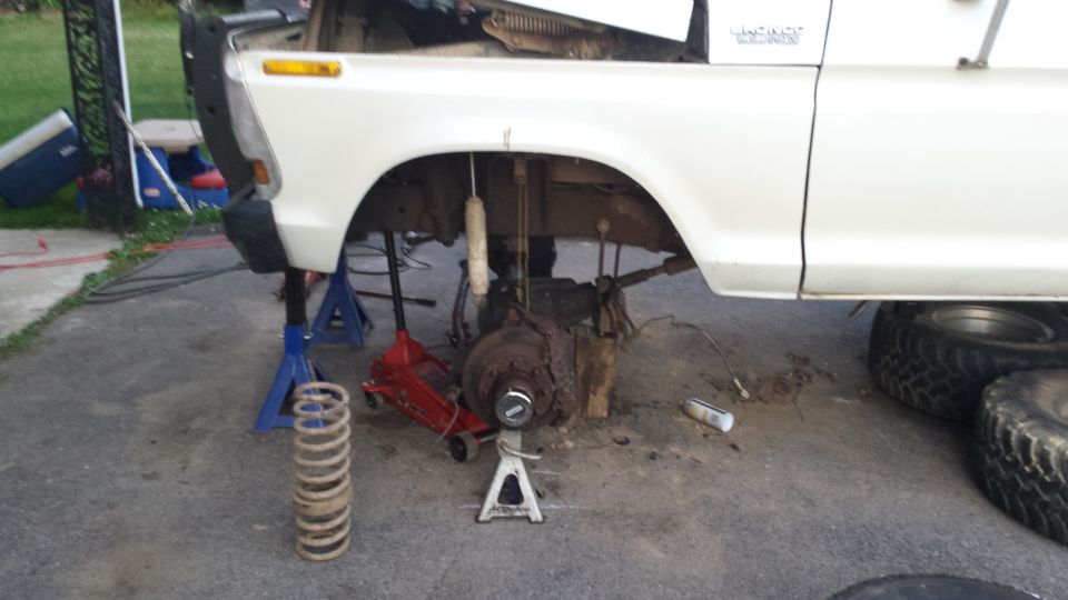 White 1979 Ford Bronco front suspension disassembled on jack stands