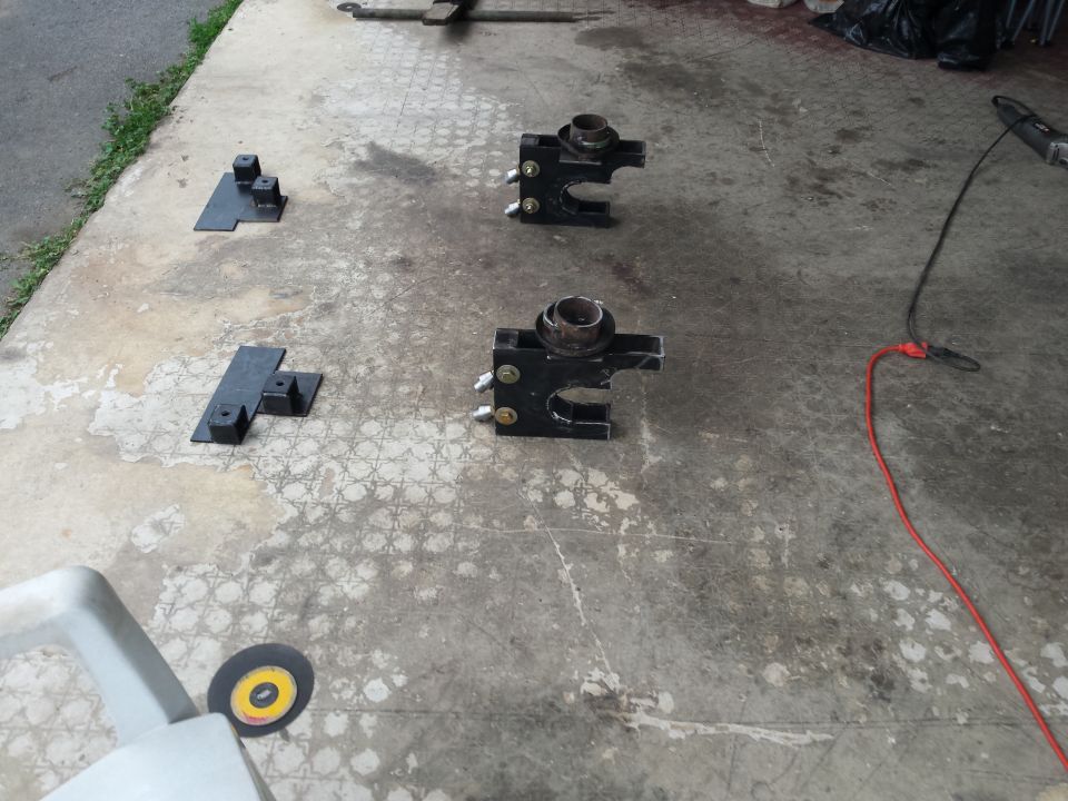 Black suspension parts and metal brackets on concrete floor