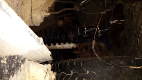Close-up of vehicle suspension components and a tire