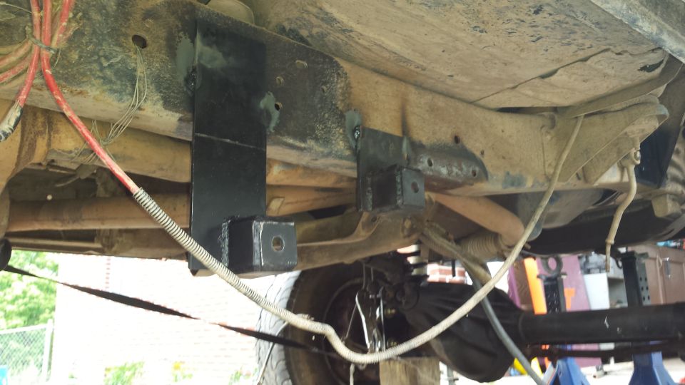 Undercarriage of a vehicle with modified suspension components and wiring. A Supermotors.net watermark is visible