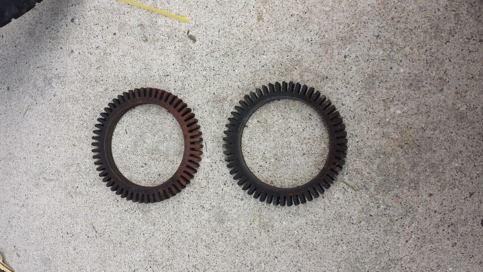 two toothed rings, one rusty, one black, on concrete