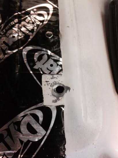 1995 Ford Bronco - Close-up of a car door panel showing sound deadening material and a hole.
