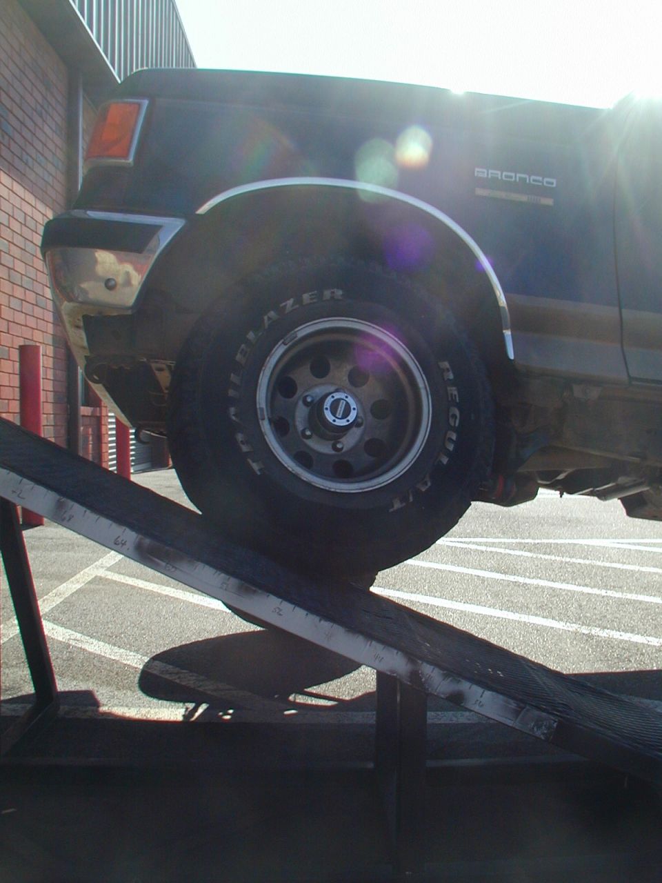 1988 Ford Bronco's front fender and wheel on a loading ramp