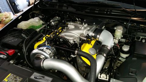 2003 Mercury Marauder - Close-up view of a modified engine bay, highlighting a supercharger and custom piping.