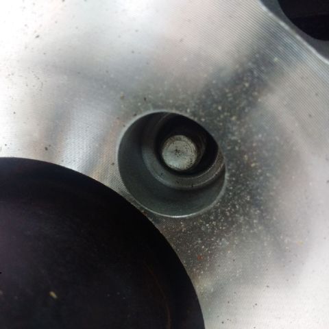 1978 Ford Bronco - A close-up view of a wheel bolt hole on a silver alloy wheel.