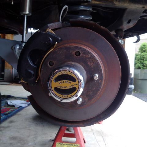 1978 Ford Bronco - Close-up of a Warn locking hub assembly on a vehicle's brake rotor.