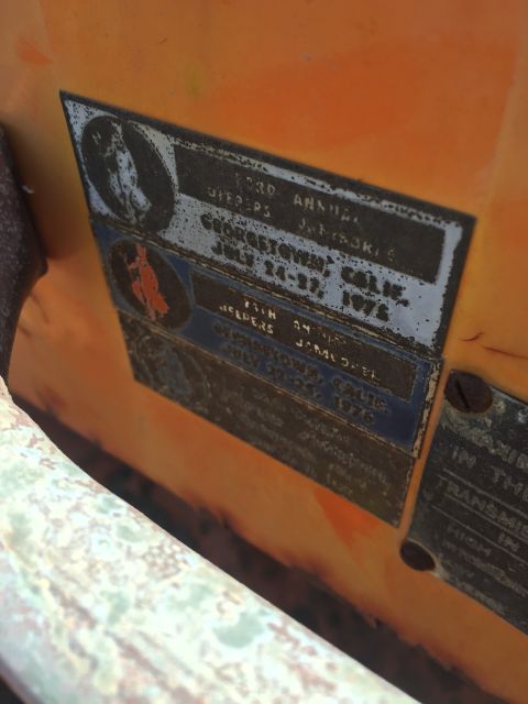 1946 Jeep Willys - A close-up view of two metal plaques affixed to an orange vehicle. The plaques detail events for "Jeepers" in Georgetown, California, in Ju…