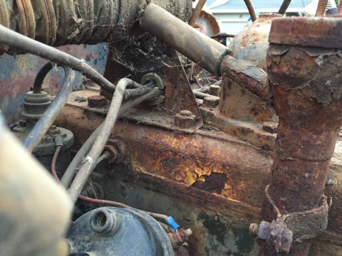 1946 Jeep Willys - This close-up image shows a heavily rusted engine component with various wires and hoses attached. The metal shows significant corrosion, w…