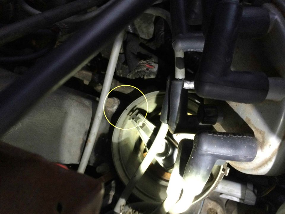 Engine bay with distributor cap and spark plug wires, bolt highlighted.