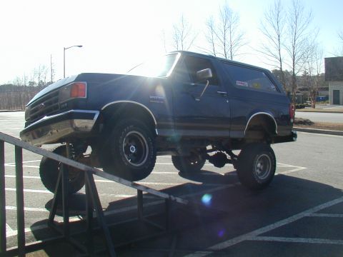 1988 Ford Bronco - This SUV is on a ramp, with its front wheels higher than the rear.