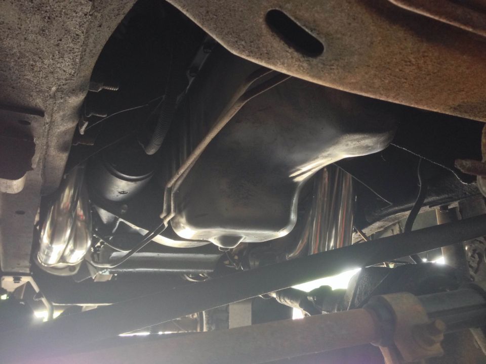 Underneath view of vehicle engine bay, oil pan, and exhaust headers.