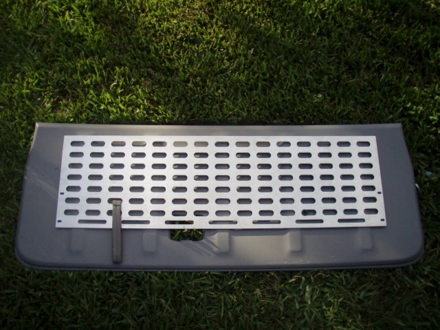 Gray tailgate with silver perforated metal insert on grass