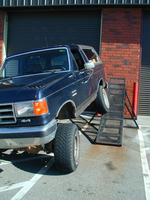 1988 Ford Bronco - This 1988 Ford Bronco is positioned on a ramp, with its 4x4 designation clearly visible on the front fender.