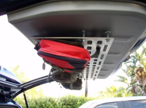 2005 Toyota 4Runner - A custom aluminum MOLLE panel is mounted to the underside of a vehicle's liftgate, holding a red first-aid bag and other gear. The panel is…