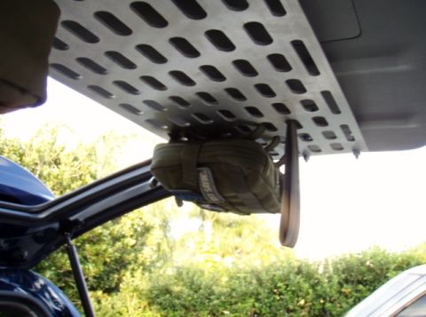 2005 Toyota 4Runner - A close-up, low-angle view of a metal storage rack mounted inside the rear of a vehicle, with a green utility pouch hanging from it. The ra…