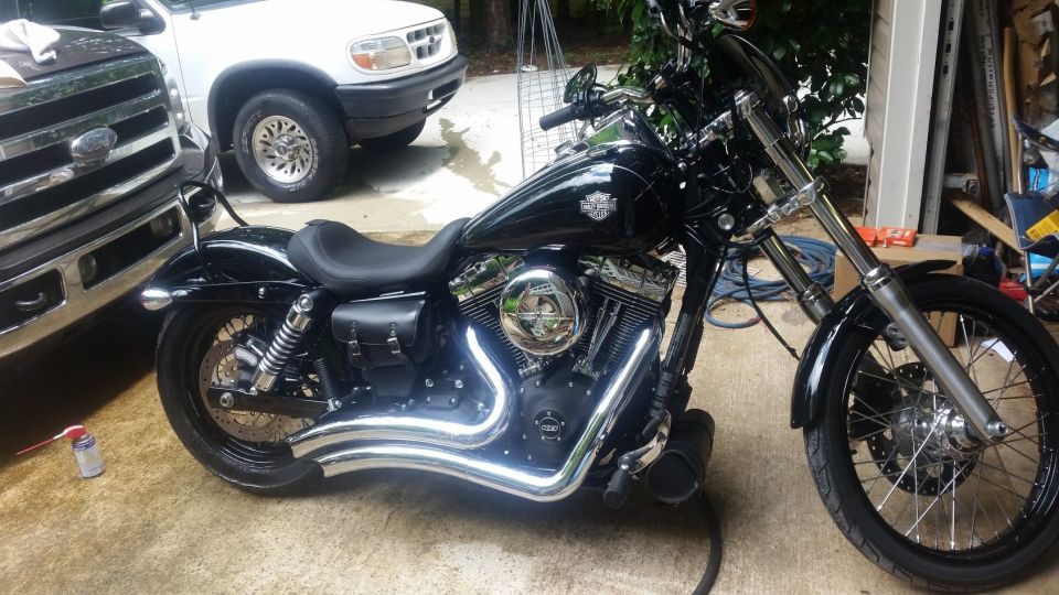 Black Harley-Davidson motorcycle parked next to a Ford pickup and white SUV.