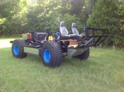 1992 Ford Bronco - A custom-built, open-chassis vehicle with two seats, large off-road tires, and a visible engine sits on a grassy lawn. The vehicle has a bl…