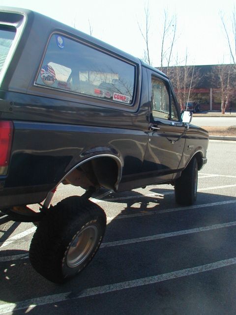 1988 Ford Bronco - Side view of a 1988 Ford Bronco, showing its lifted suspension and off-road tires.