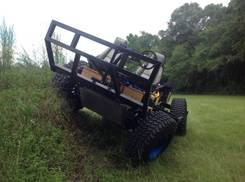 1992 Ford Bronco - A custom-built off-road vehicle with a roll cage and two seats is parked on a grassy slope with trees in the background. The vehicle has la…