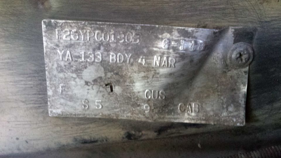 Weathered embossed Ford truck data plate with CUS and CAB codes, screwed to the body