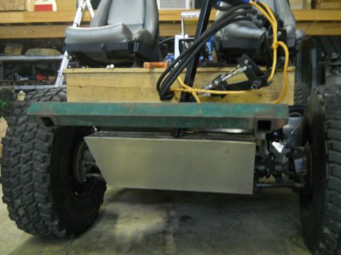 1992 Ford Bronco - The side view of a custom-built off-road vehicle shows a large tire, a green metal frame, and a silver metal box mounted underneath the cha…