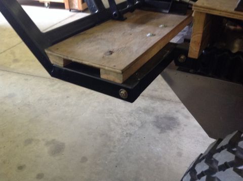 1992 Ford Bronco - A close-up view shows a wooden platform mounted on a black metal frame, attached to a vehicle. The platform appears to be part of a custom…