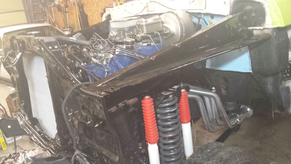 1978 Ford Bronco engine bay with custom exhaust and red/white shocks