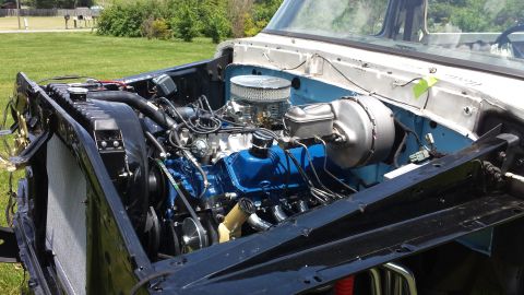 1978 Ford Bronco - The engine bay of a classic Ford truck, likely a Bronco, is shown with a bright blue engine block, chrome air cleaner, and a large radiator…