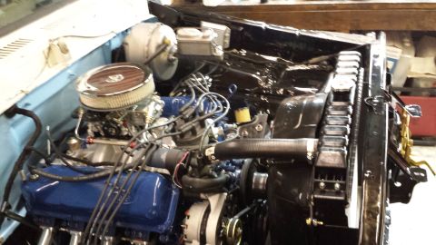 1978 Ford Bronco - A close-up view of a classic V8 engine bay, featuring a blue Ford engine with a chrome air cleaner and carburetor. The engine is installed…
