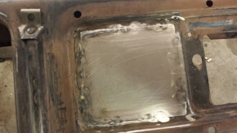 Welded patch on a rusty metal vehicle panel