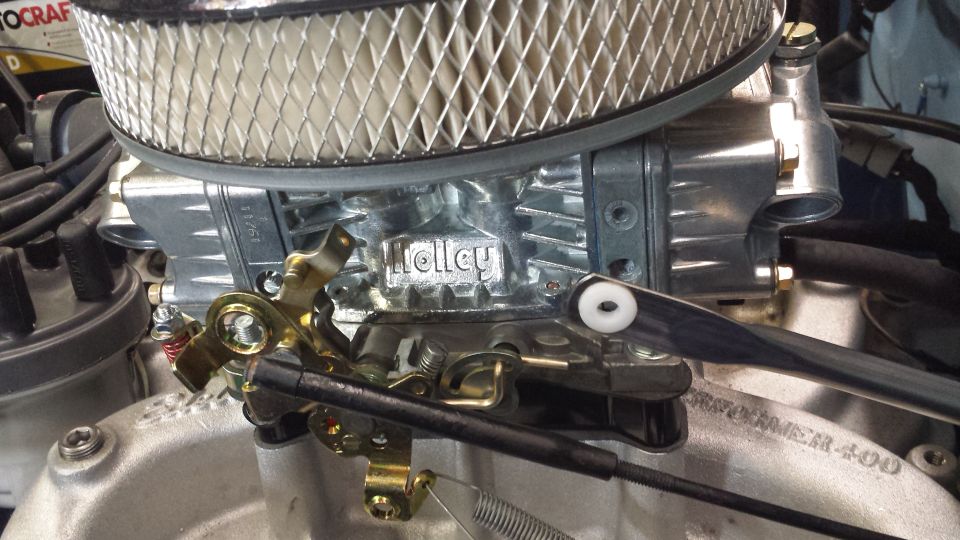 Close-up of a Holley carburetor with air filter and linkage.