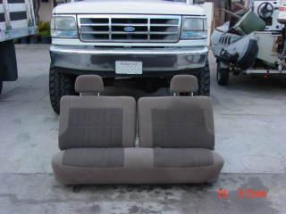 1992 Ford Bronco - A bench seat is positioned in front of a 1992 Ford Bronco. The vehicle has a California license plate.