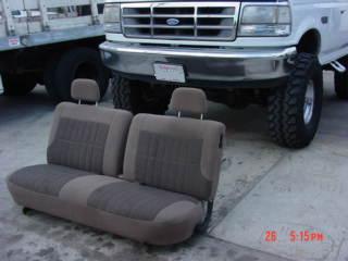 1992 Ford Bronco - Bench seat from a 1992 Ford Bronco is placed in front of the vehicle.