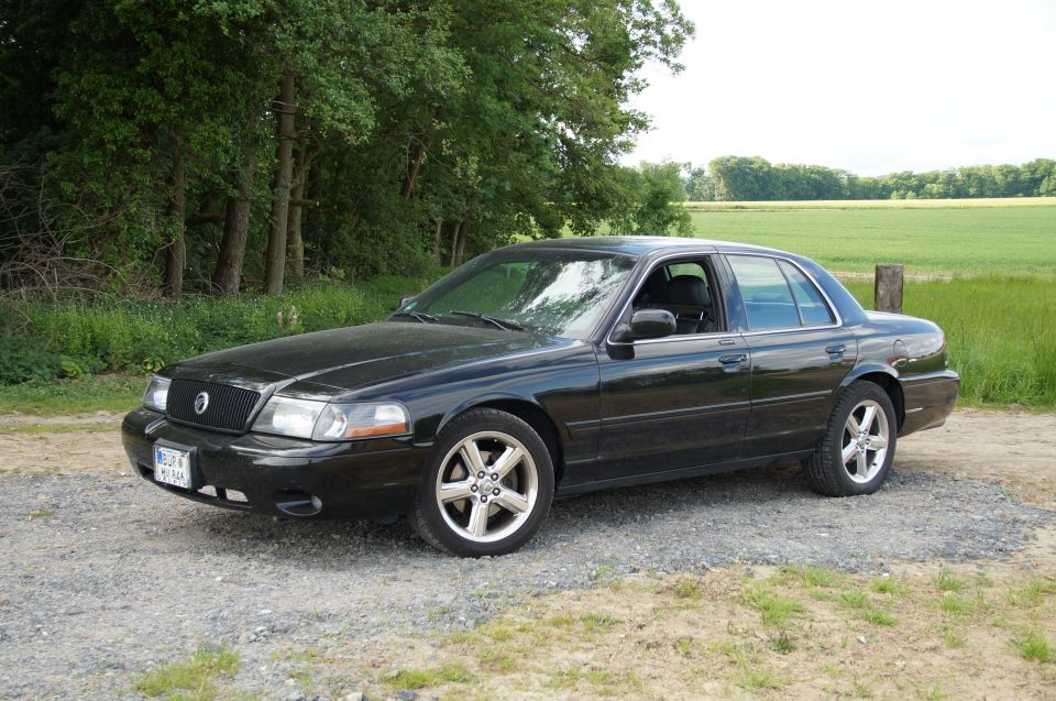 Black 2003 Mercury Marauder parked on gravel road in front of field