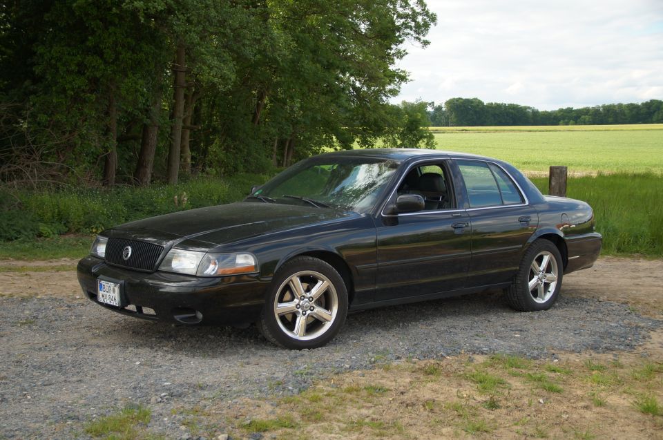 Black 2003 Mercury Marauder parked on gravel road, 3/4 front driver's side view.