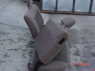 1992 Ford Bronco - A tan fabric bench seat with adjustable headrests is shown from a side angle.